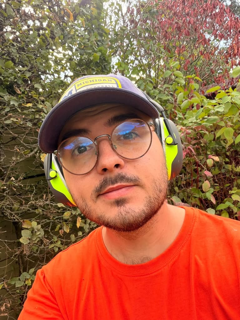 Ugo Beugnies, jardinier paysagiste, casque antibruit sur les oreilles pendant une taille de haie